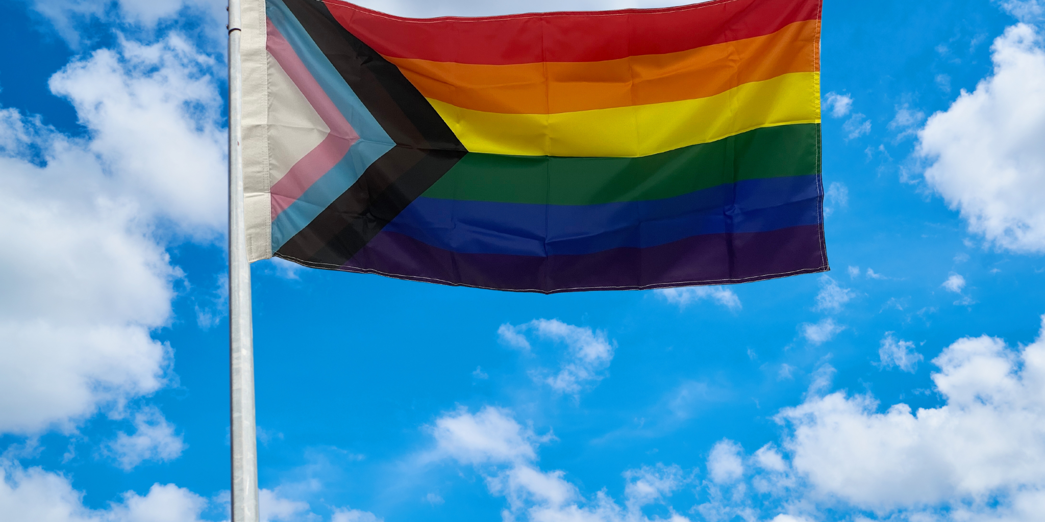 Progressive pride flag flying on pole