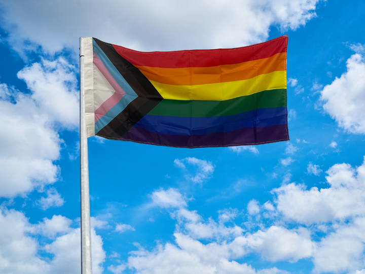 Progressive pride flag flying on pole
