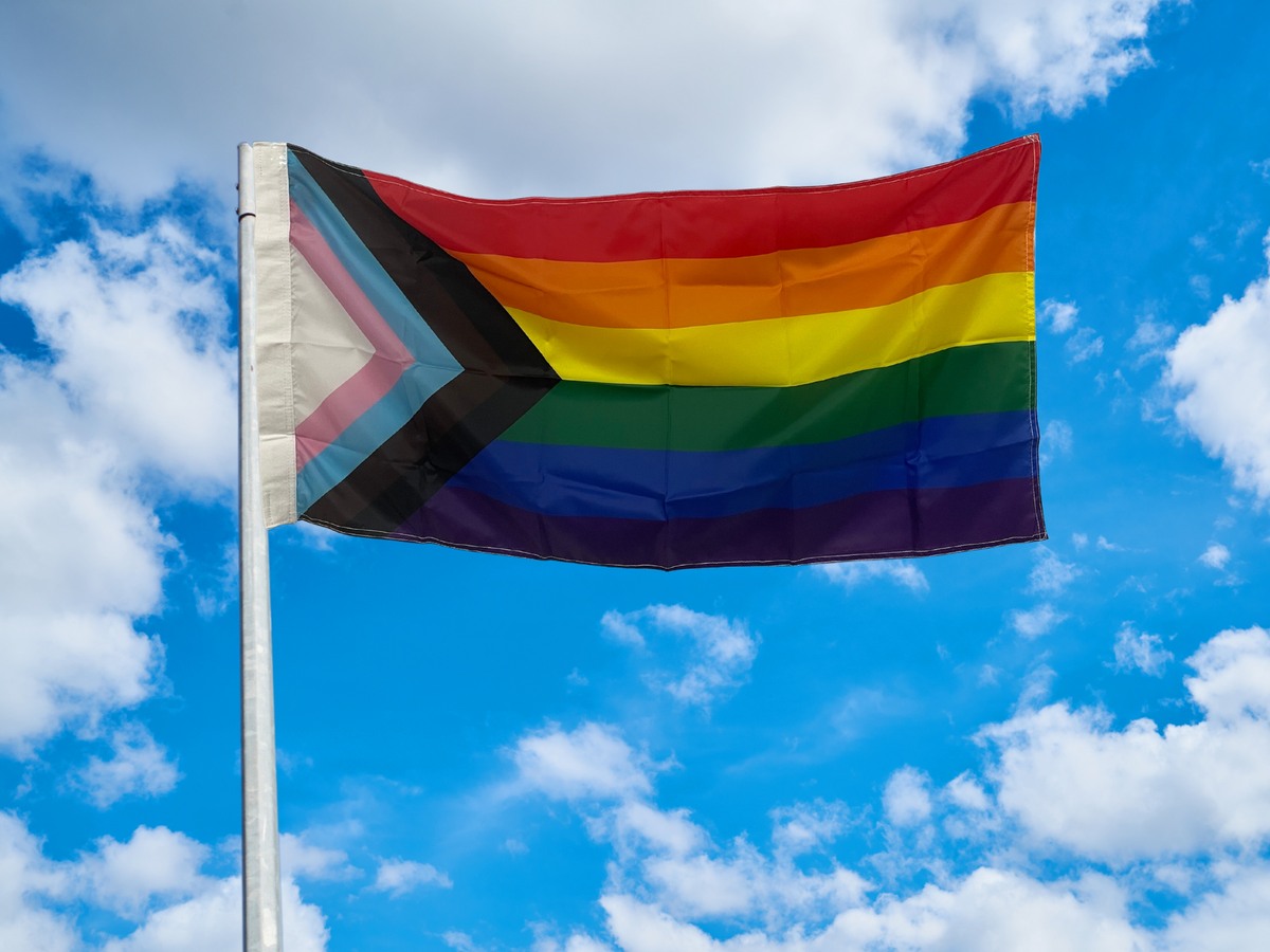 Progressive pride flag flying on pole