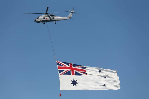 White Australian Ensign being flown under helicopter